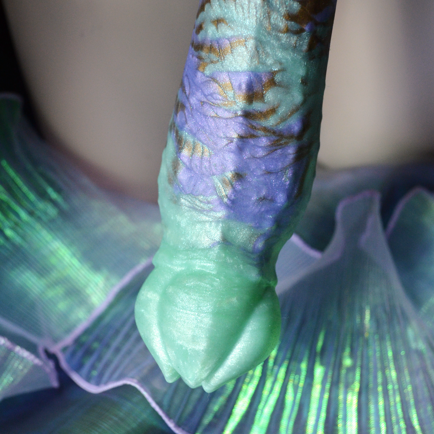 Bulbe de Nymf Berges Scintillantes, un dildo fantasy floral en silicone aux marbrures multicolores et pailletées.  