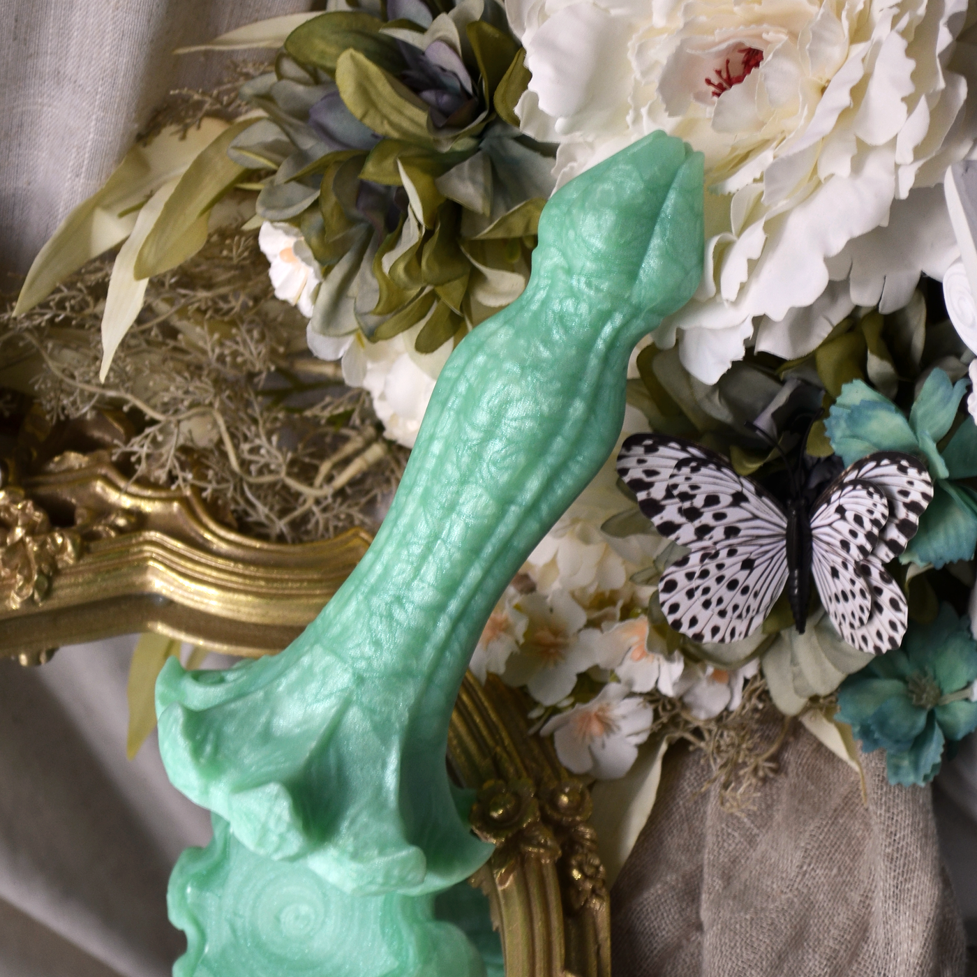 Un dildo fantasy en forme de fleur en silicone vert pastel de la marque Fera Daemon