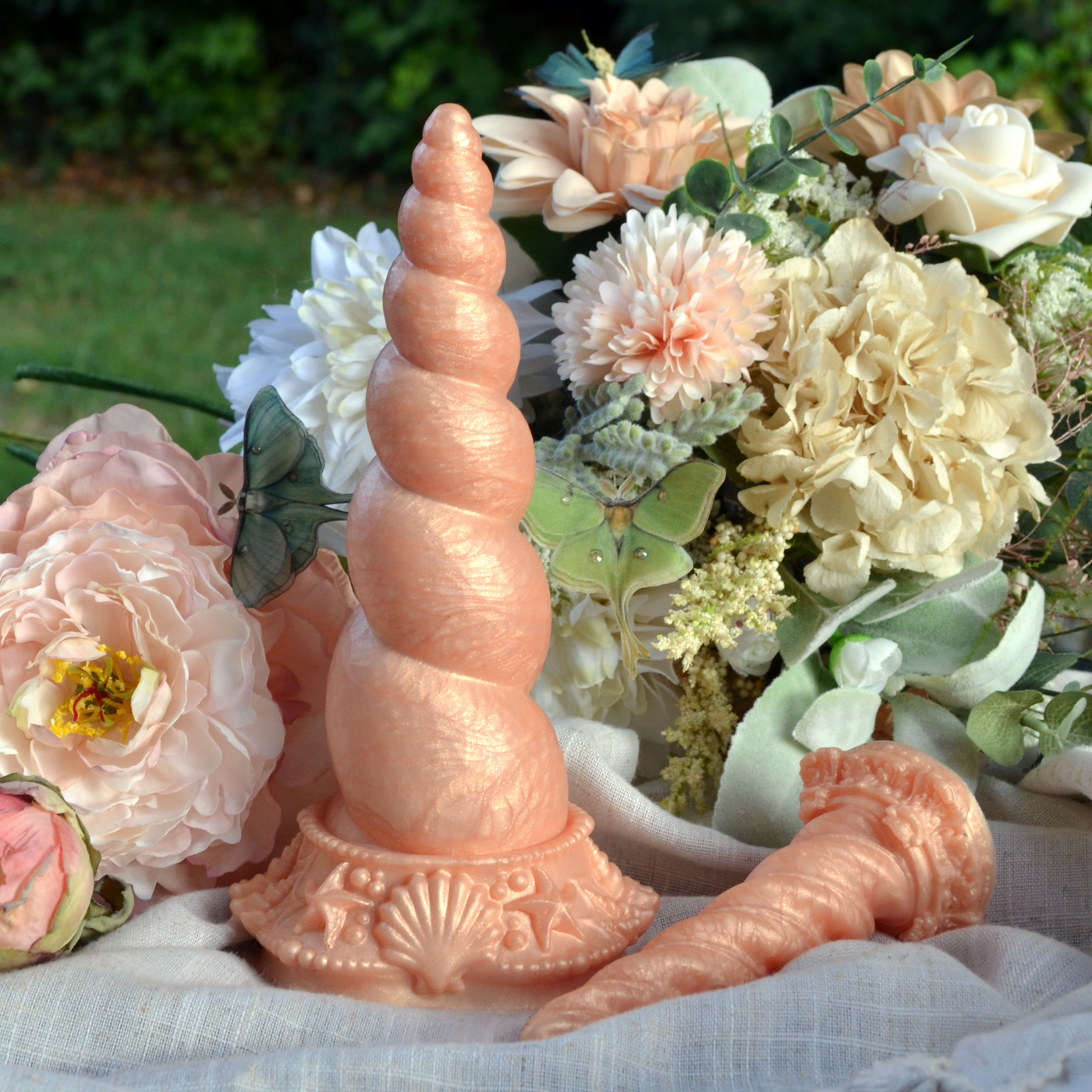 Un sextoy licorne en silicone orange pastel de Fera Daemon. Fênra est un dildo large à l'esthétique féérique.