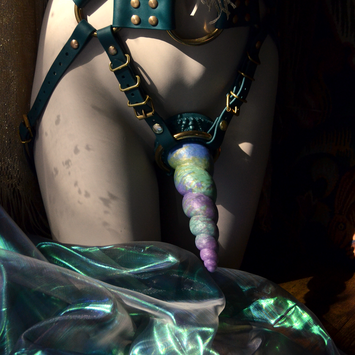 Harnais strap-on vert sapin avec un dildo artistique Fênra Nymphéas. Un sextoy progressif inspiré de Monet créé par Fera Daemon idéal pour le pegging.