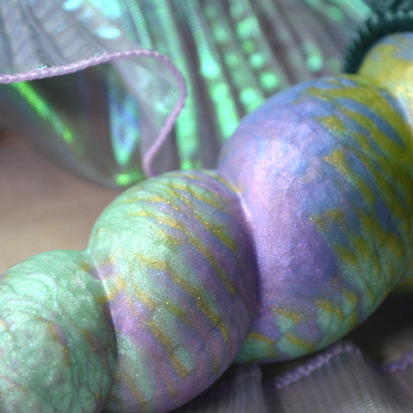 Nuances et paillettes du silicone des sextoys fantasy de Fera Daemon avec le coloris vert et mauve Nymphéas.