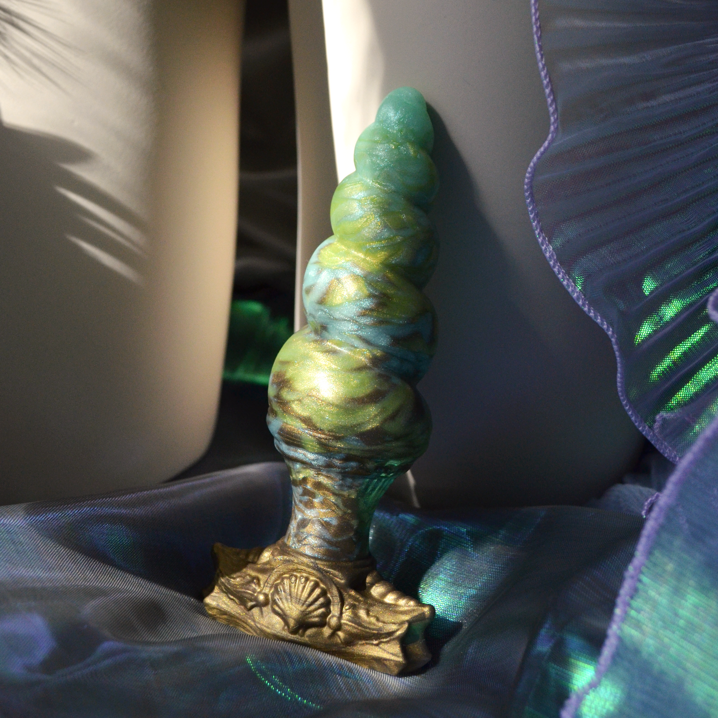 Plug anal artistique en silicone vert marbré. Un plug fantasy en forme de coquillage elfique par Fera Daemon.