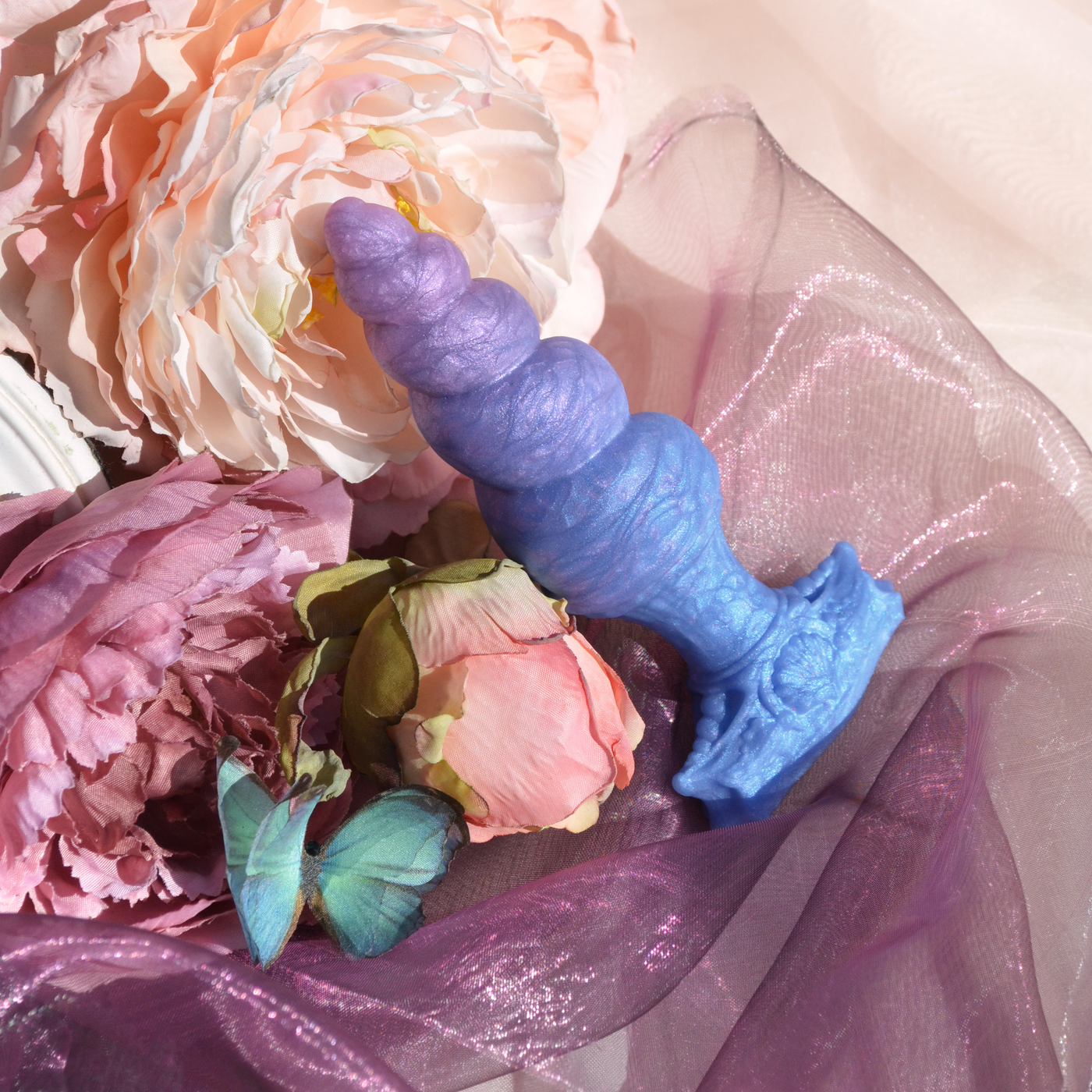 Plug anal corne de licorne torsadée en silicone bleu et violet. Un plug fantasy à l'esthétique queer et féérique.