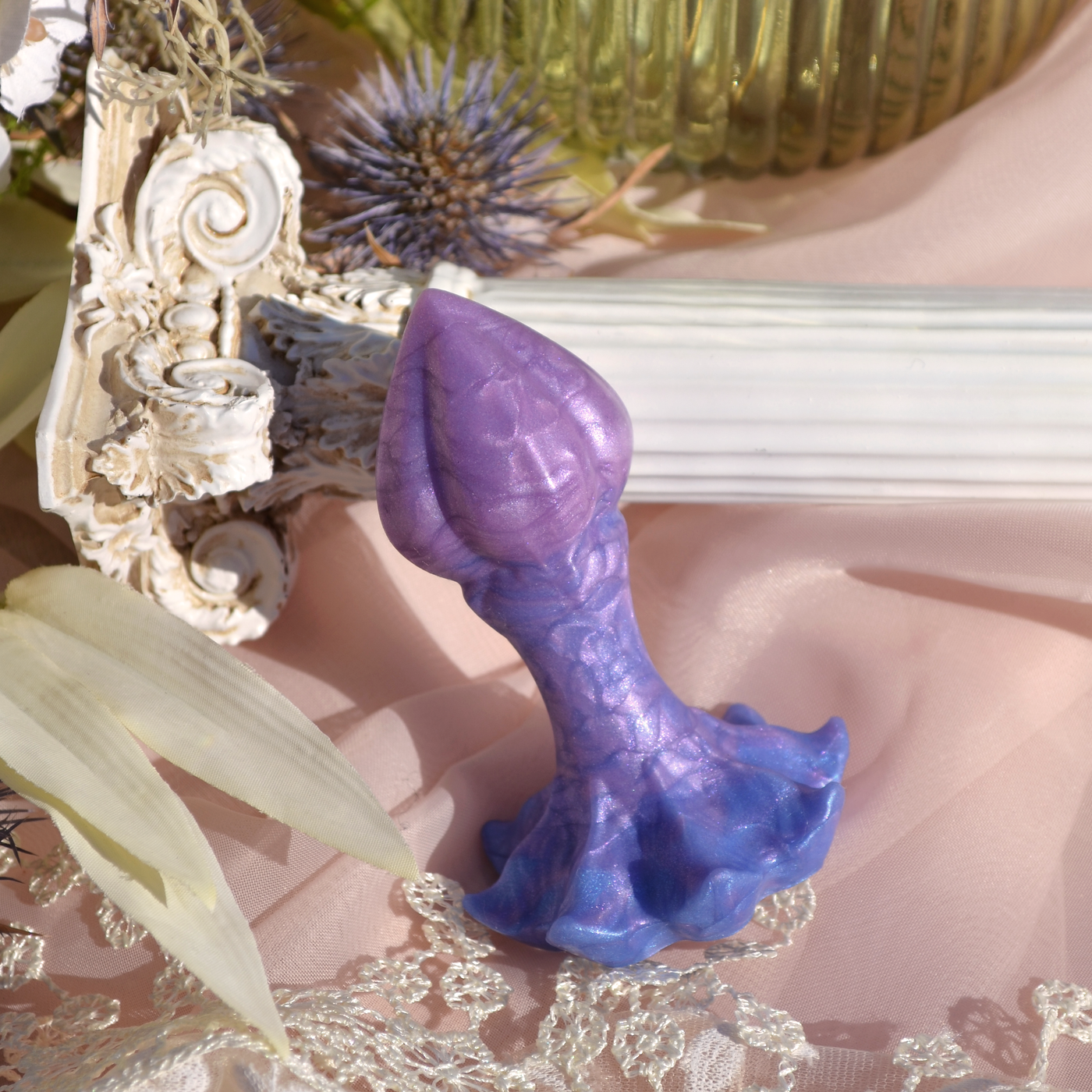 Plus vaginal fairy de Fera Daemon. Un plug fantasy en silicone lilas et bleu à l'esthétique poétique et printanière.