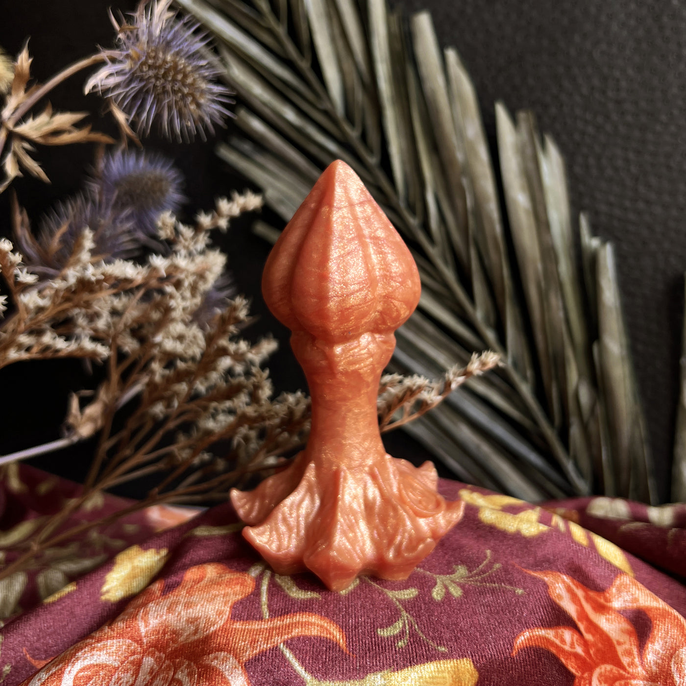 Plug anal de couleur orange en silicone, un sextoy fantasy en forme de bourgeon de fleur coloré et luxueux