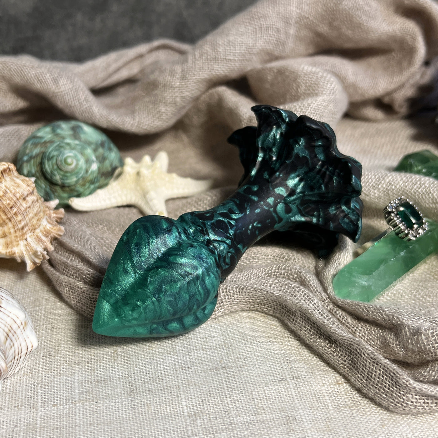 Plug fantasy en dégradé de noir à vert inspiré d'un bouton de fleur magique, ce sextoy anal a de belles marbrures en silicone