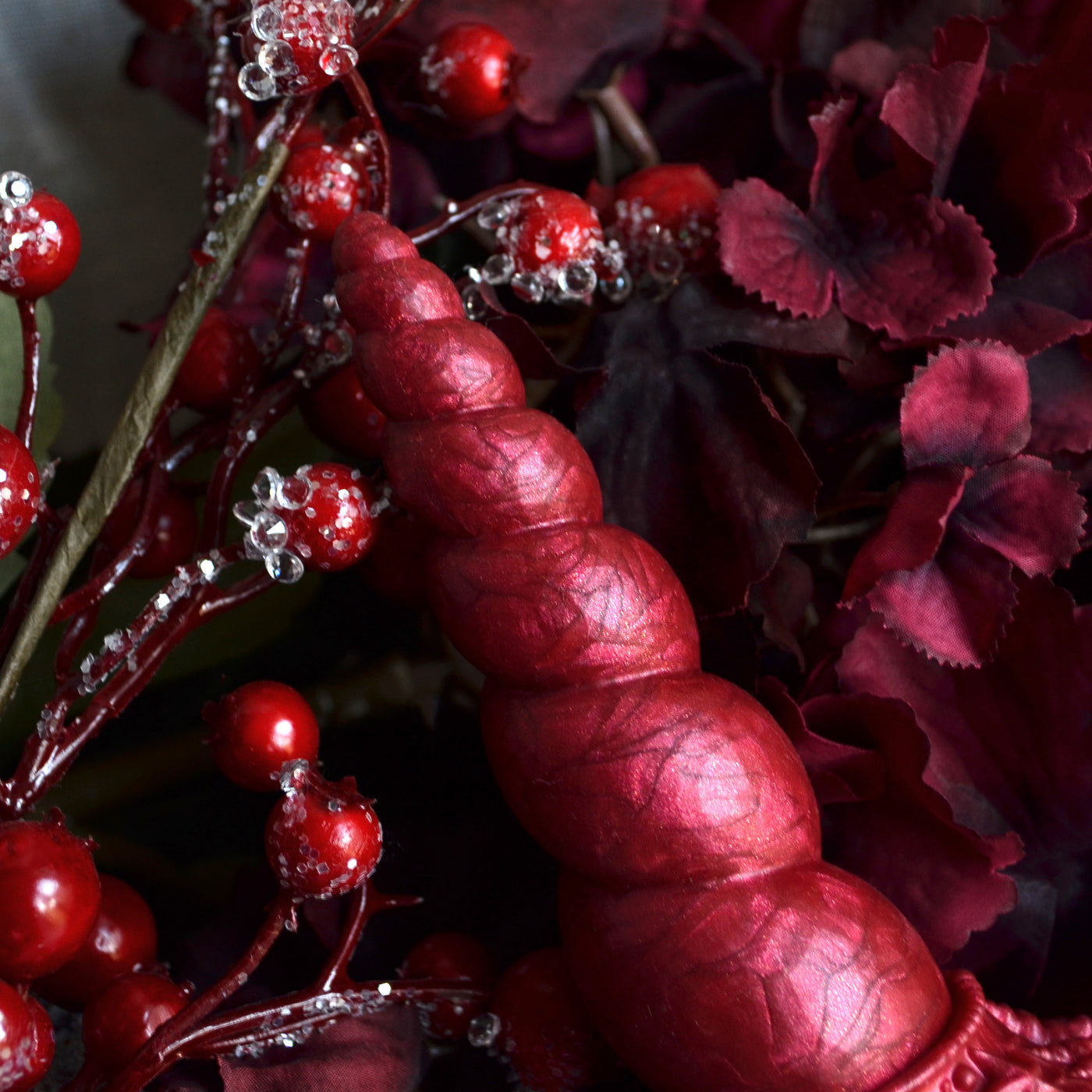 Zoom sur les petits knots en spirales du sextoy Fênra Océa, une corne d'hippocampe dans le coloris rouge Rubis Volcanique