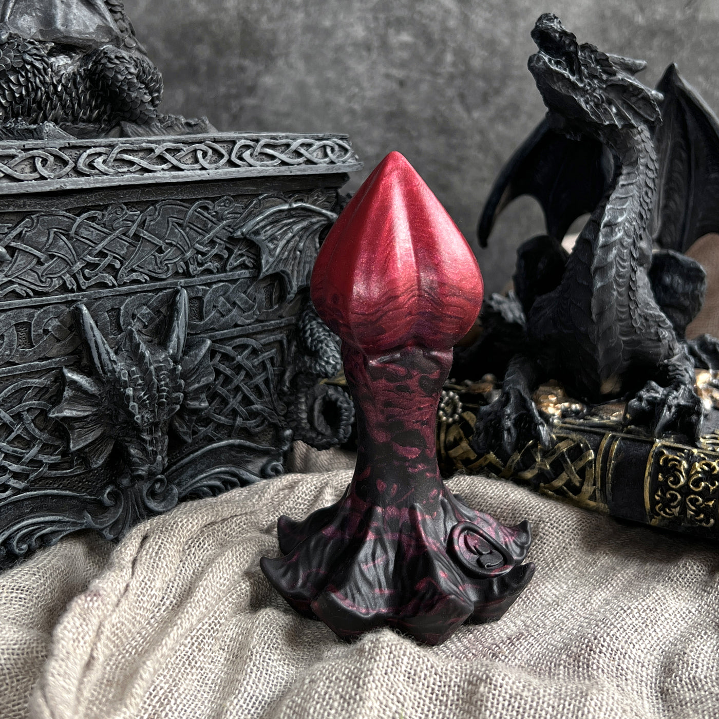 Plug anal en silicone rouge et noir dans un style dark fantasy et gothique, le modèle Nymf Plug Draconique de Fera Daemon est inspiré d'un bourgeon de fleur